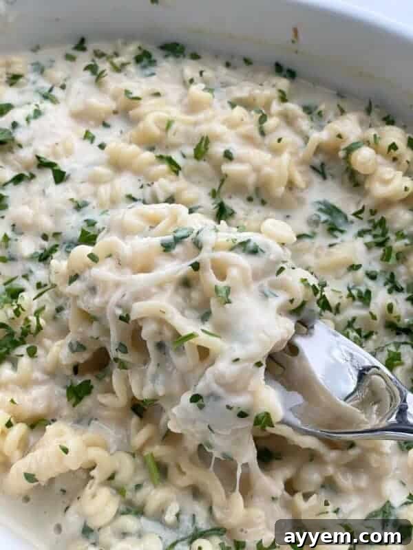 Parmesan Lemon Garlic Pasta in a baking dish being scooped up with a spoon
