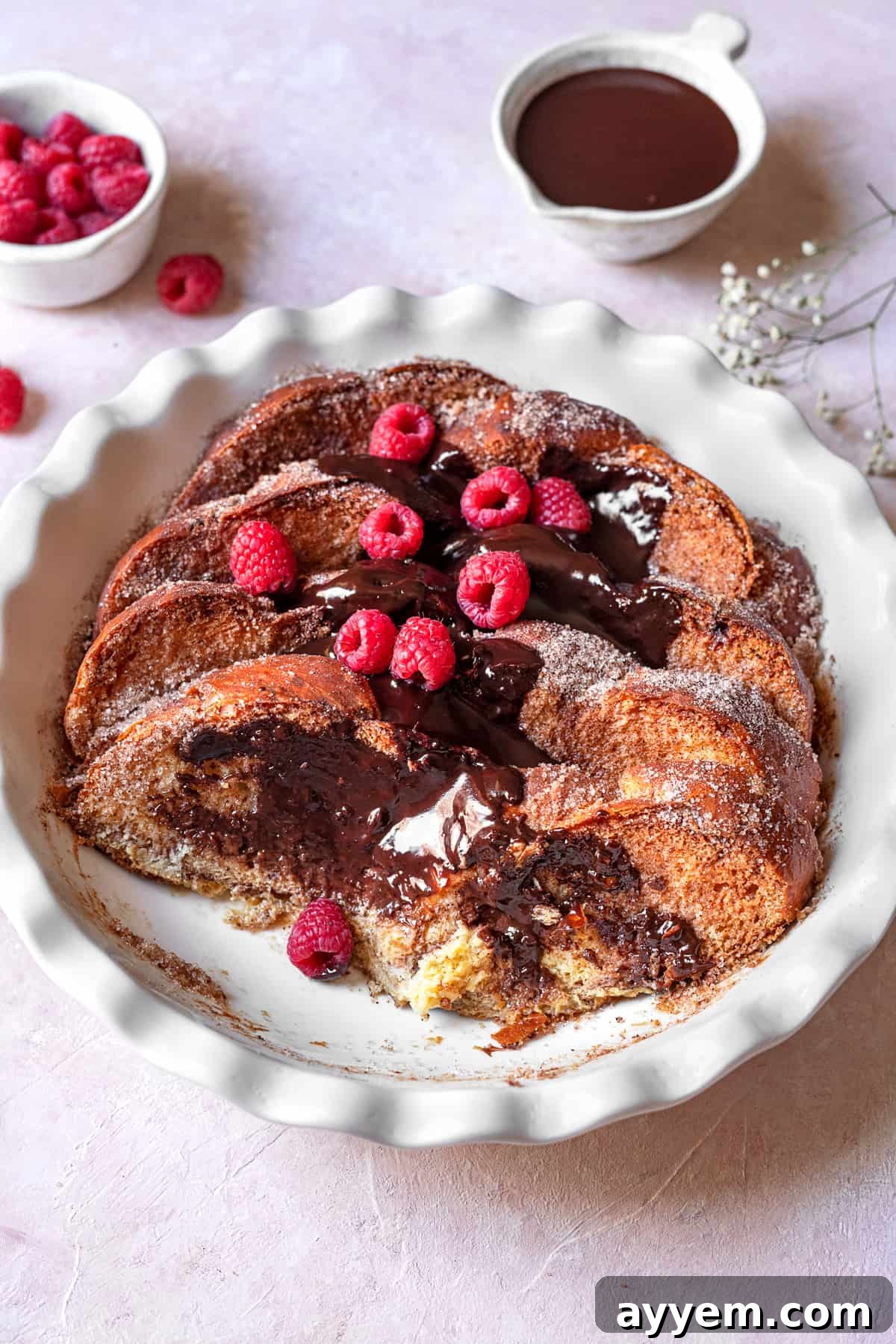 closeup of churro french toast with chocolate and raspberries