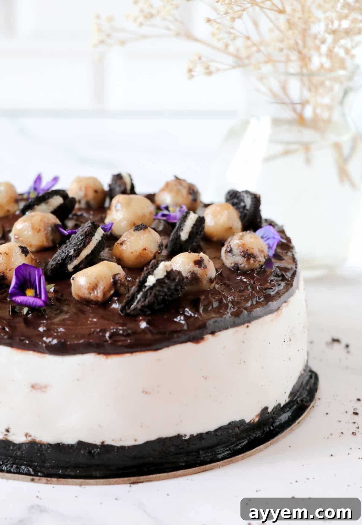 A side view of the whole Billy Miner Cookie Ice Cream Pie, showing its impressive height and layers of crust, ice cream, and fudge.