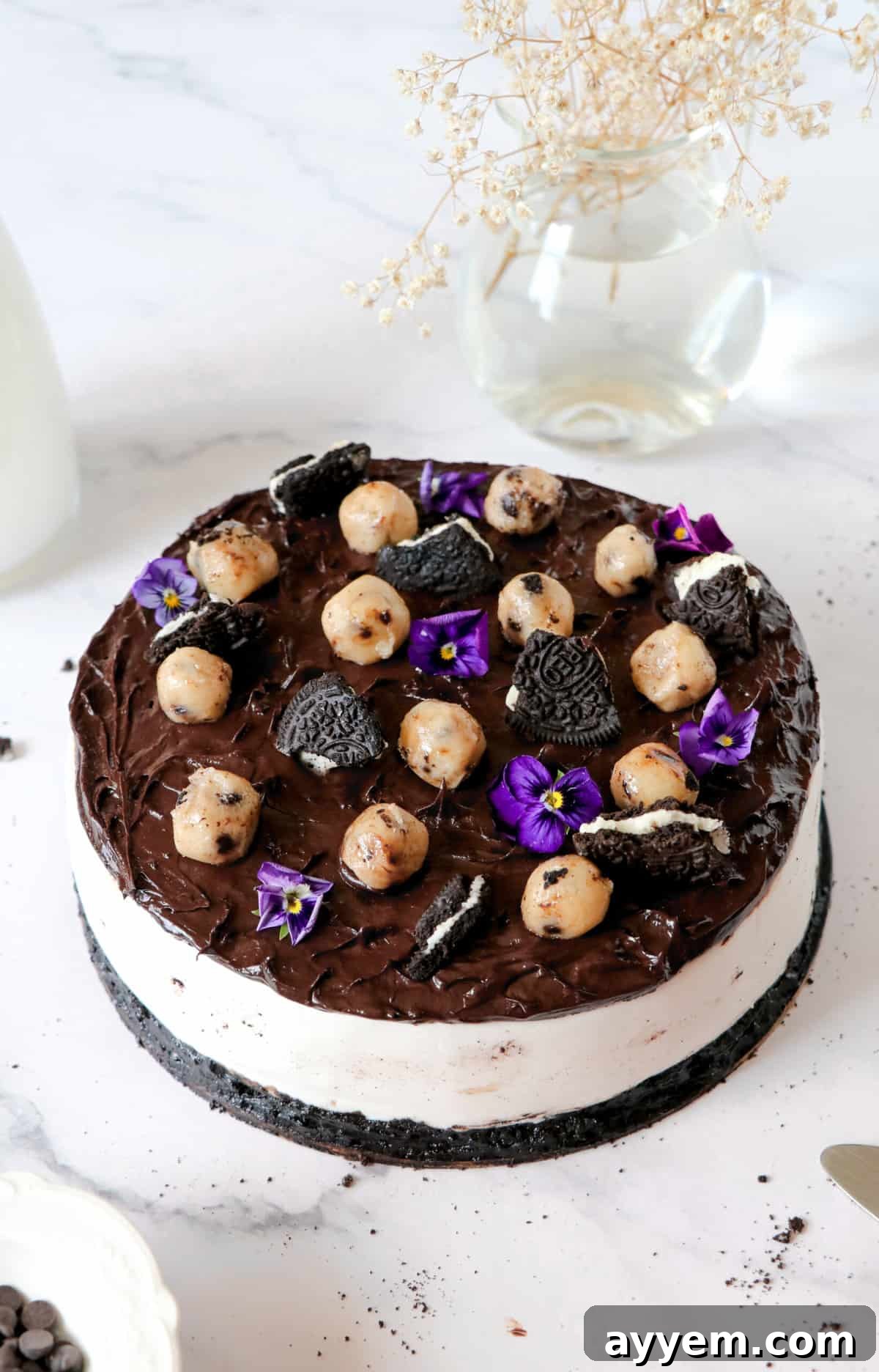 An overhead shot of the entire Billy Miner Cookie Ice Cream Pie, generously topped with an array of Oreo pieces and edible cookie dough balls, highlighting its rich and inviting surface.