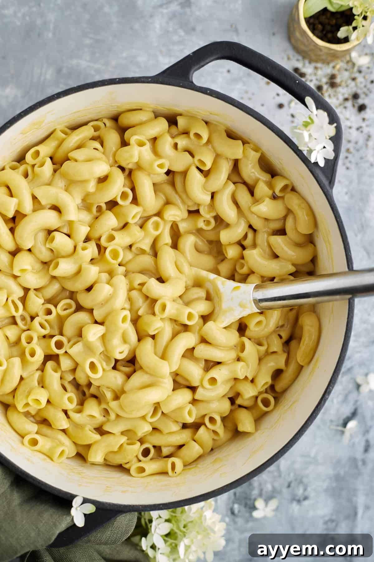 One Pot Wonder Mac and Cheese 5 overhead image of one pot mac and cheese in a large pot being stirred with a spoon
