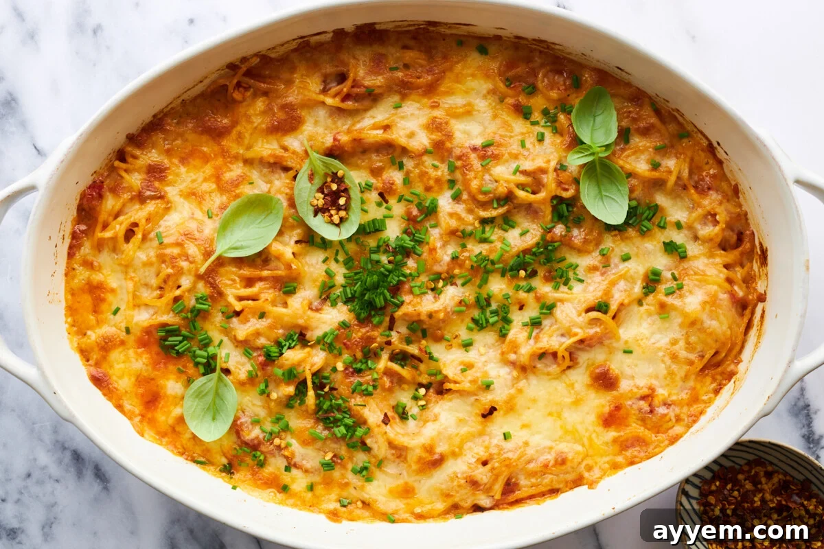 Oven baked spaghetti topped with melted, bubbly cheese, fresh from the oven.
