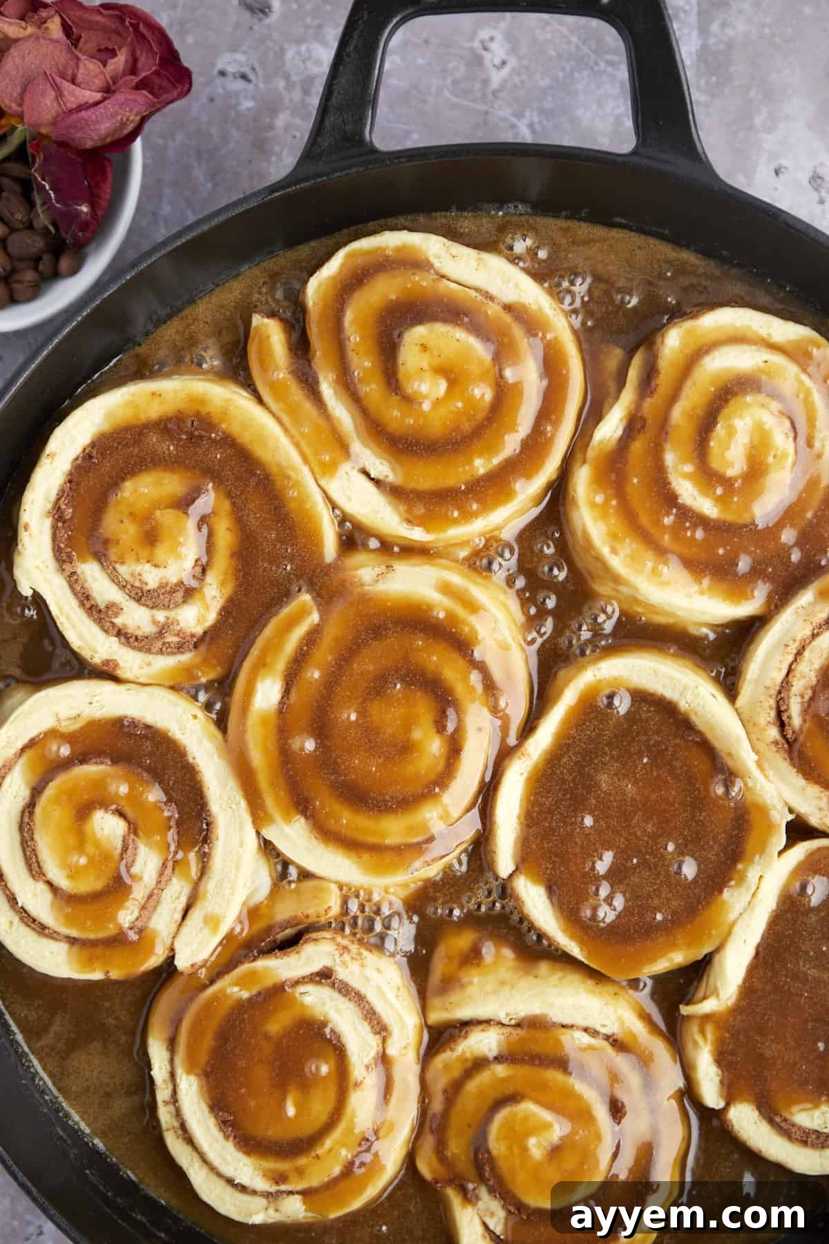 More raw cinnamon rolls are added to the bundt pan, layered with caramel sauce for an even coating.