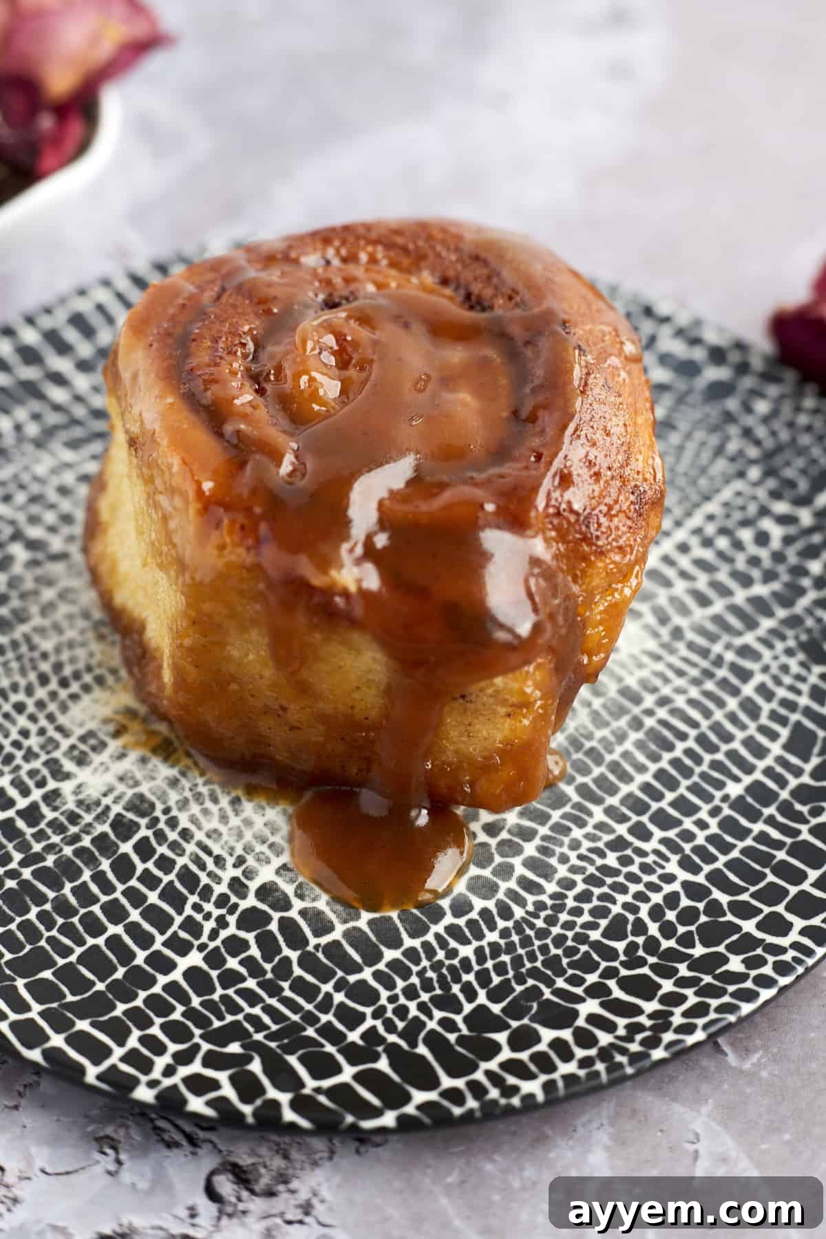 A single slice of caramel macchiato cinnamon roll cake on a plate, showing the soft, gooey interior.