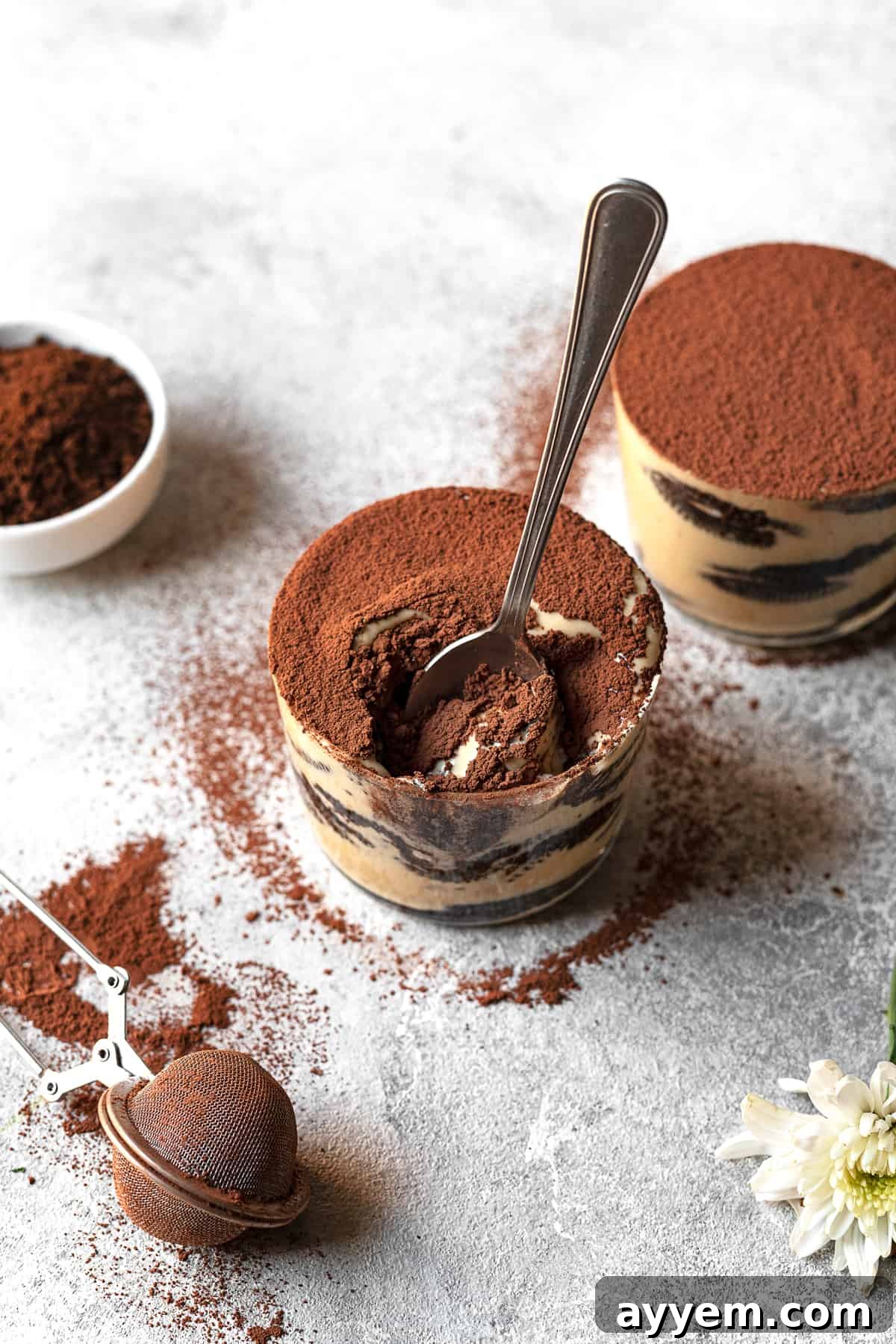 A close-up shot of a spoon gently scooping into a jar of layered Oreo tiramisu, highlighting the rich texture.
