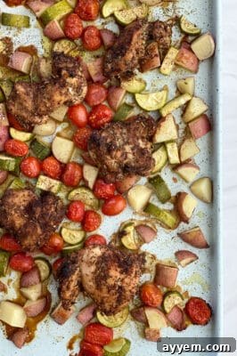 overhead image of sheet pan chicken thighs and veggies, perfectly cooked and ready to serve.