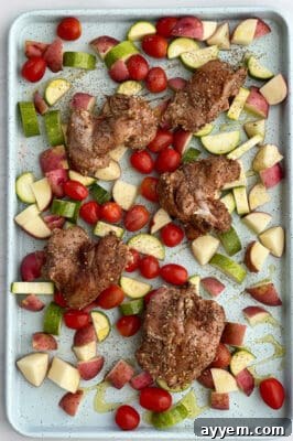 Raw Sheet Pan Chicken Thighs and Veggies on a baking sheet