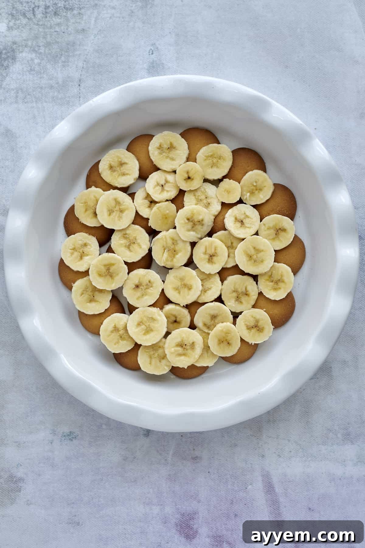 Freshly sliced bananas elegantly layered over the Nilla wafers in a baking dish.