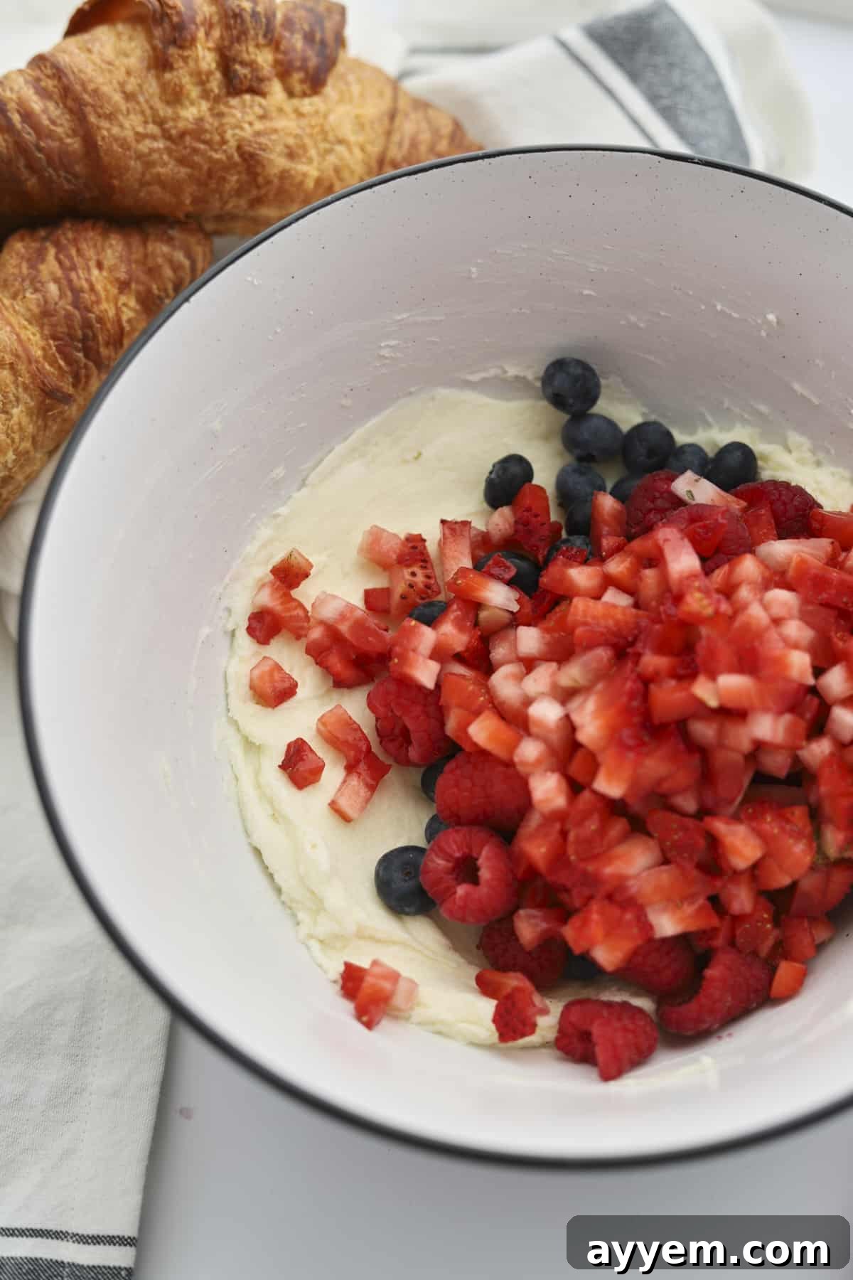 A bowl of fresh blueberries, raspberries, and diced strawberries ready for the filling.
