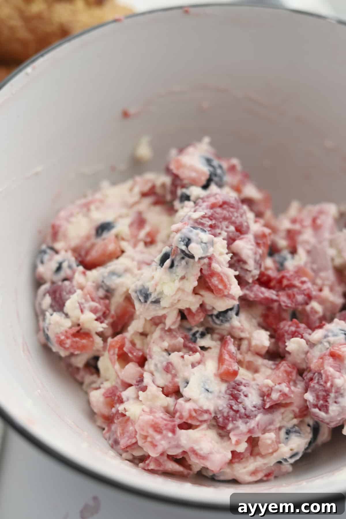 A bowl filled with the creamy berry and cream cheese mixture, ready to stuff the croissants.