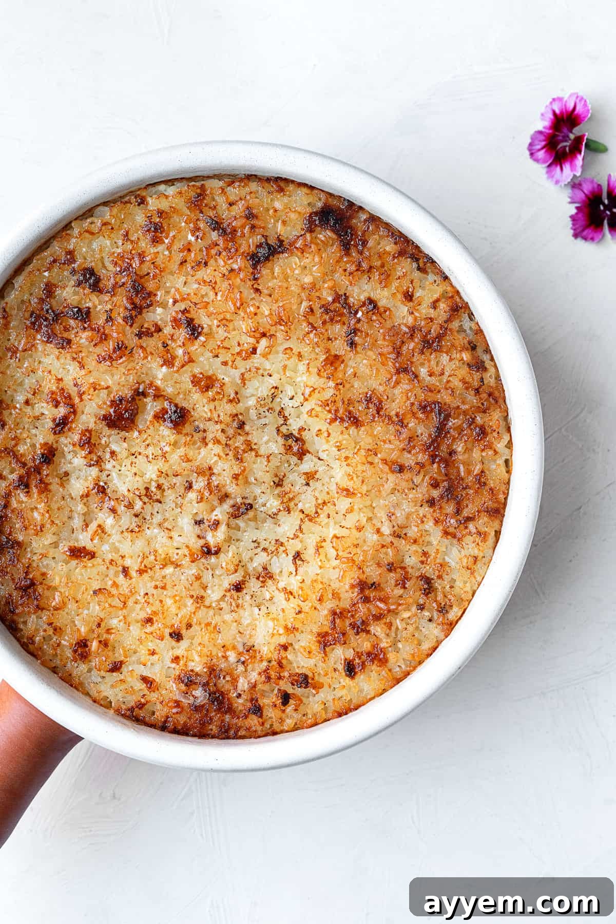 Overhead shot of a beautifully cooked circular dish of Egyptian baked rice, garnished and ready to be served.