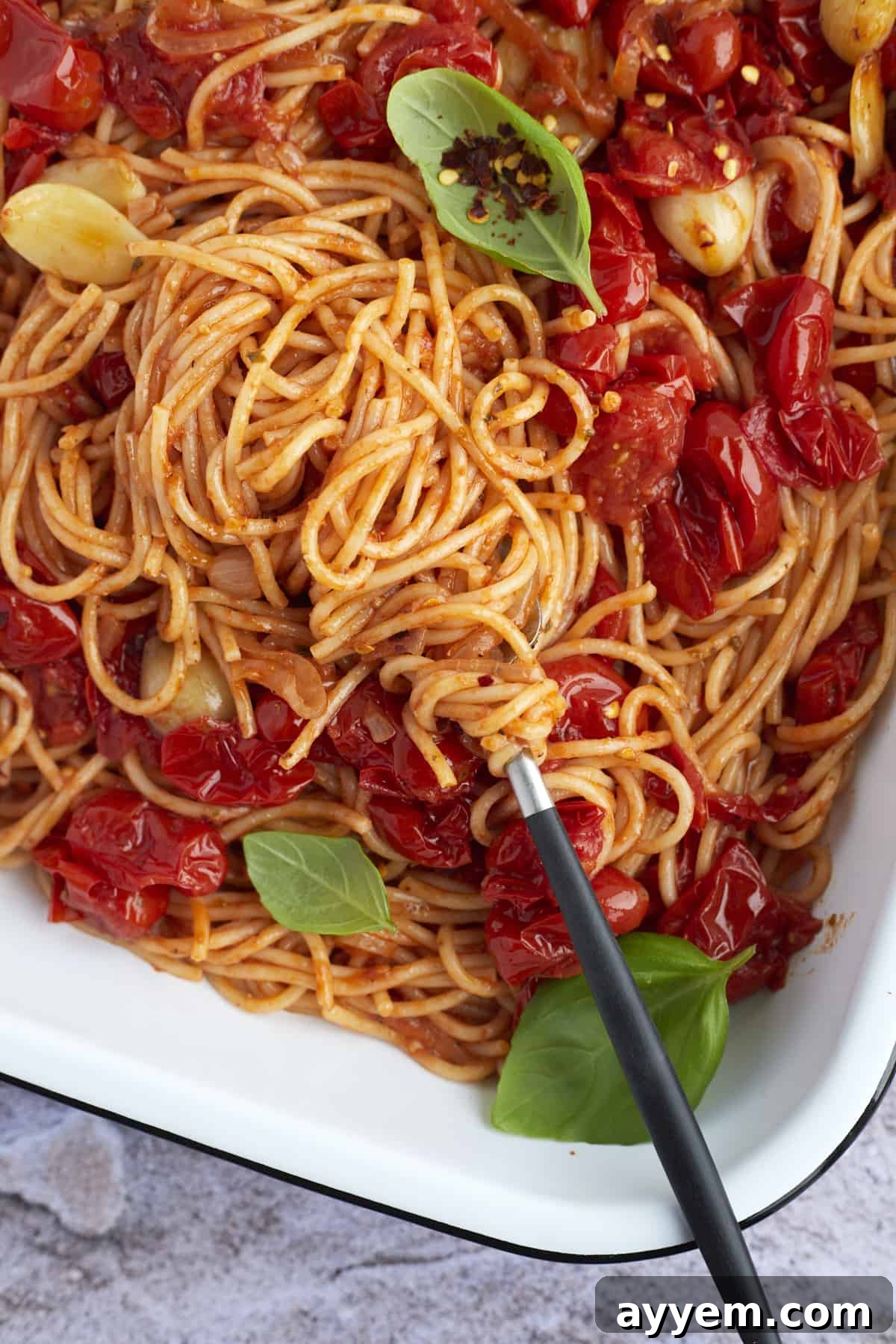 easy one pan spaghetti in a baking dish being swirled with a fork
