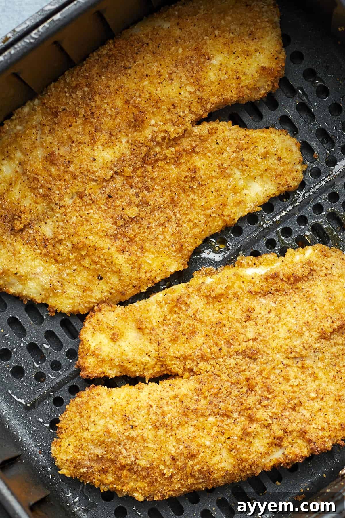 Close-up of perfectly cooked air fryer tilapia, golden and crispy.