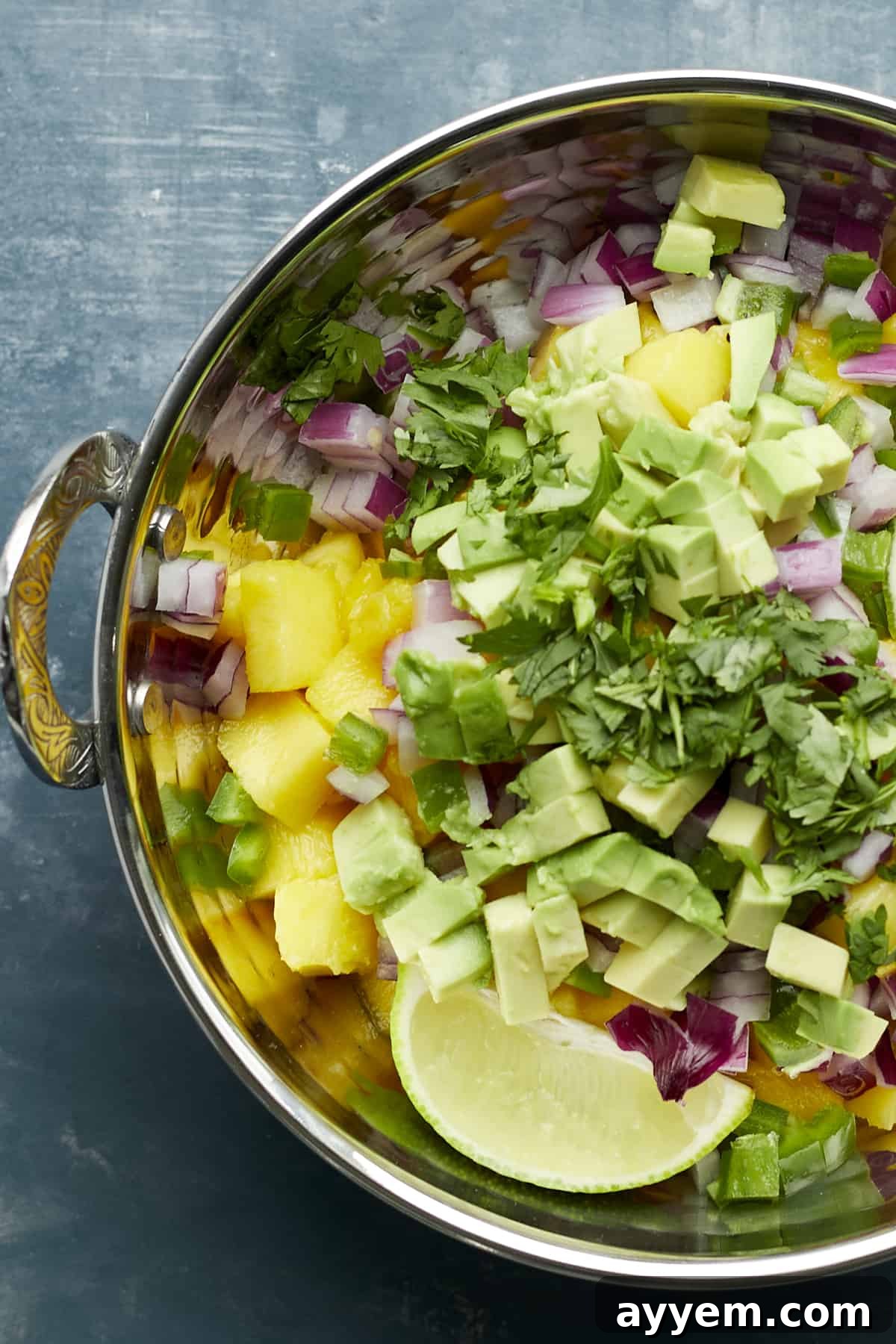 Overhead image of fresh ingredients for mango salsa in a bowl, before mixing.