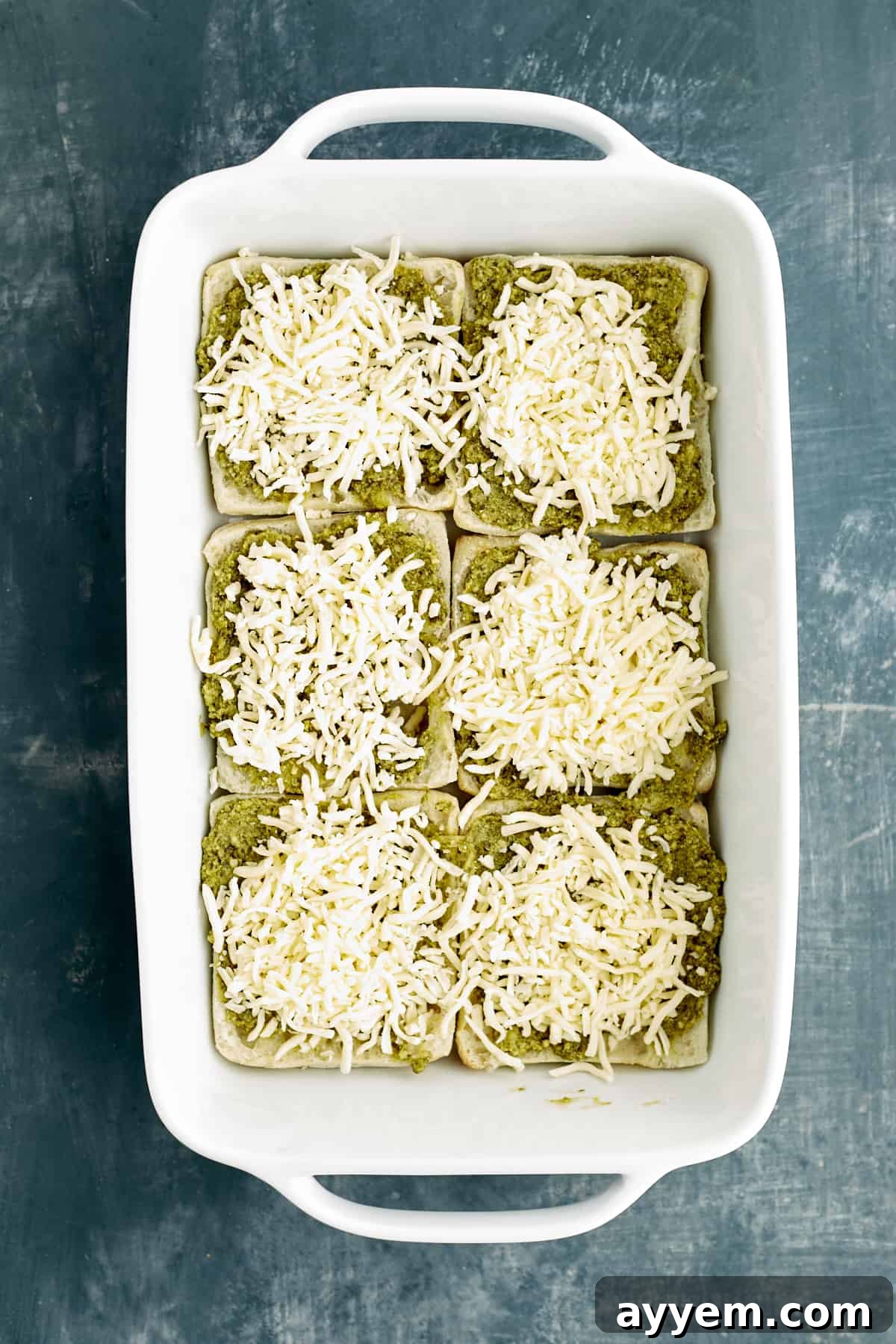 Fresh Turkey Caprese Sandwich 5 Pesto-covered ciabatta bread in a baking dish, now layered with melted cheese.