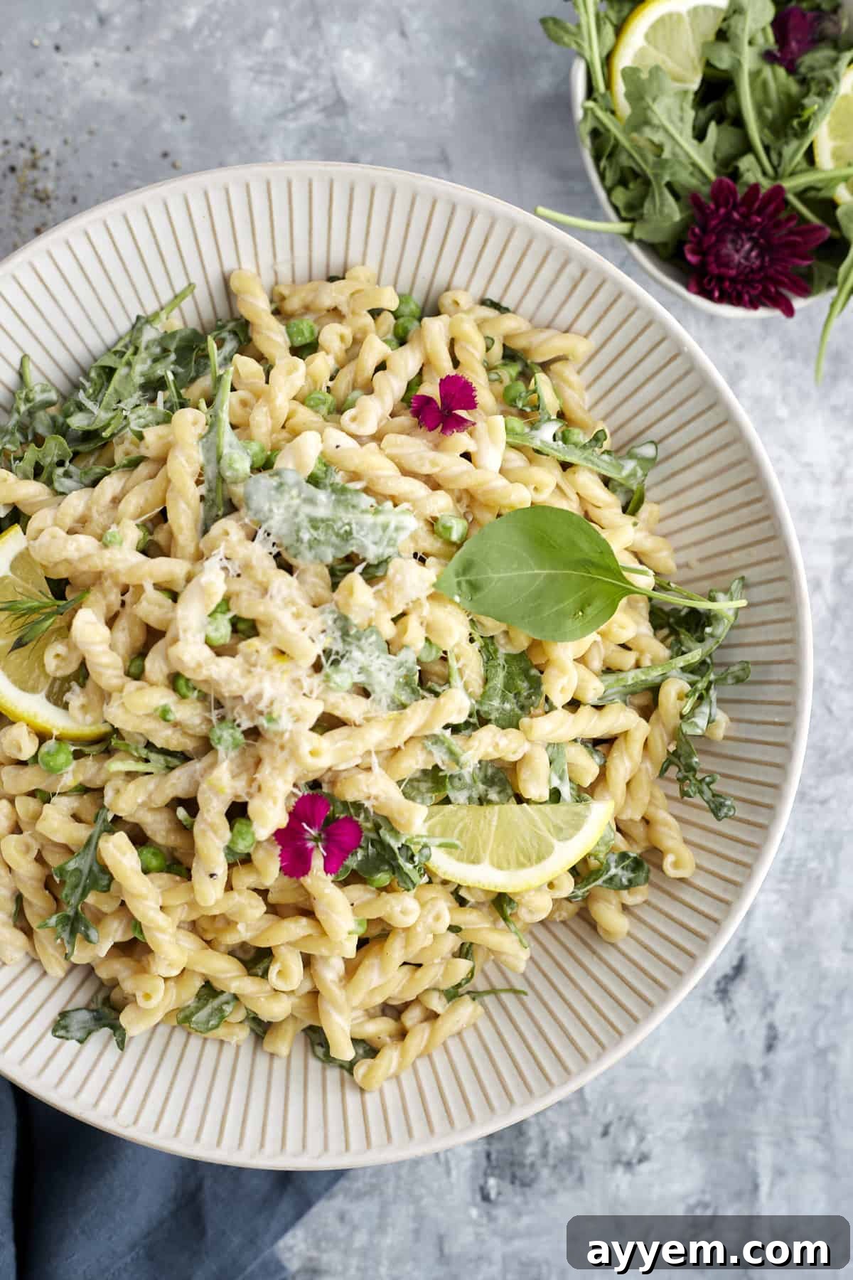Creamy Lemon Ricotta One-Pot Delight 2 overhead image of a white bowl full of lemon ricotta pasta topped with fresh herbs and a lemon wedge, highlighting its fresh appeal