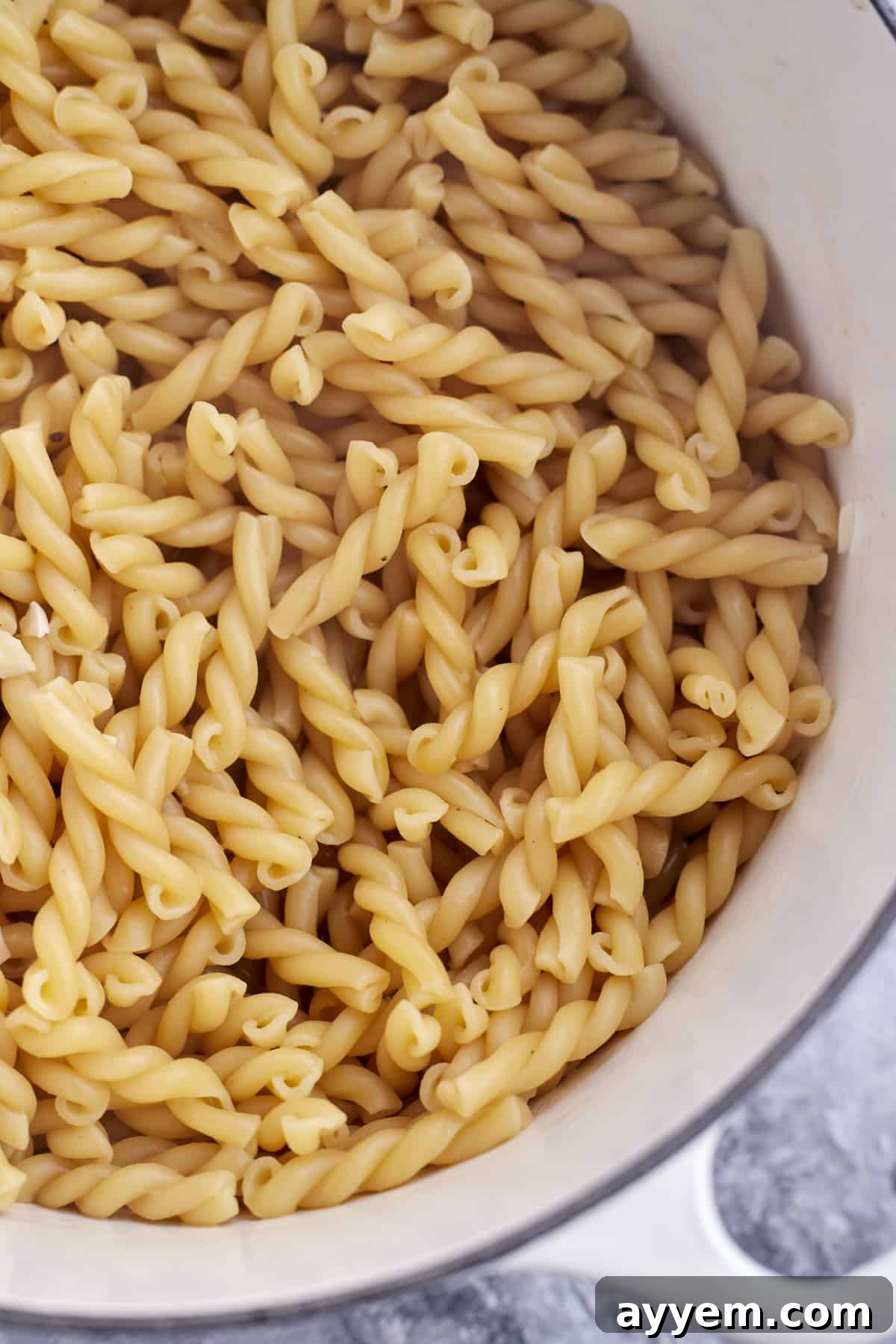 Creamy Lemon Ricotta One-Pot Delight 4 uncooked pasta noodles in a pot, showing the simplicity of the one-pot method