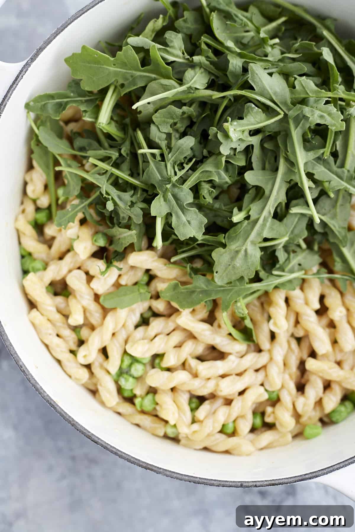 Creamy Lemon Ricotta One-Pot Delight 6 lemon pasta in a pot with arugula and peas, ready to be tossed and served