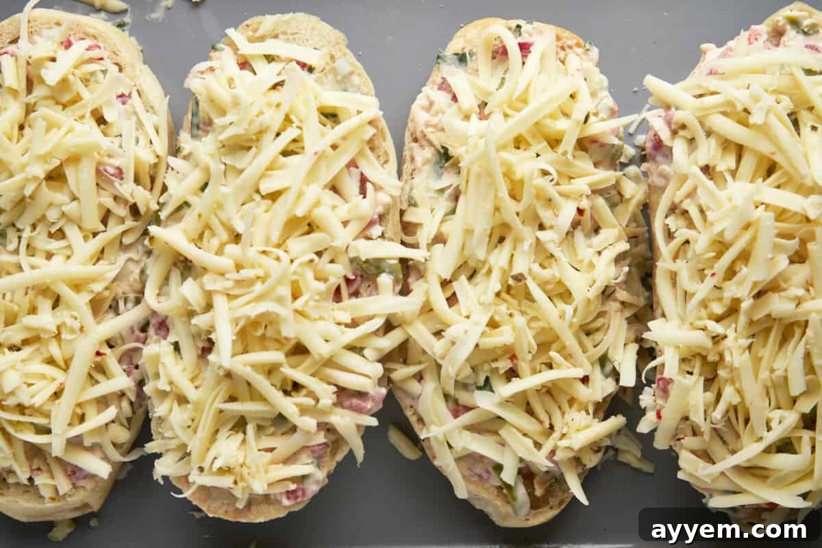 The ultimate Olive Cheese Bread, loaded with olives, onions, pimientos, garlic, and gooey cheese on crusty French bread.