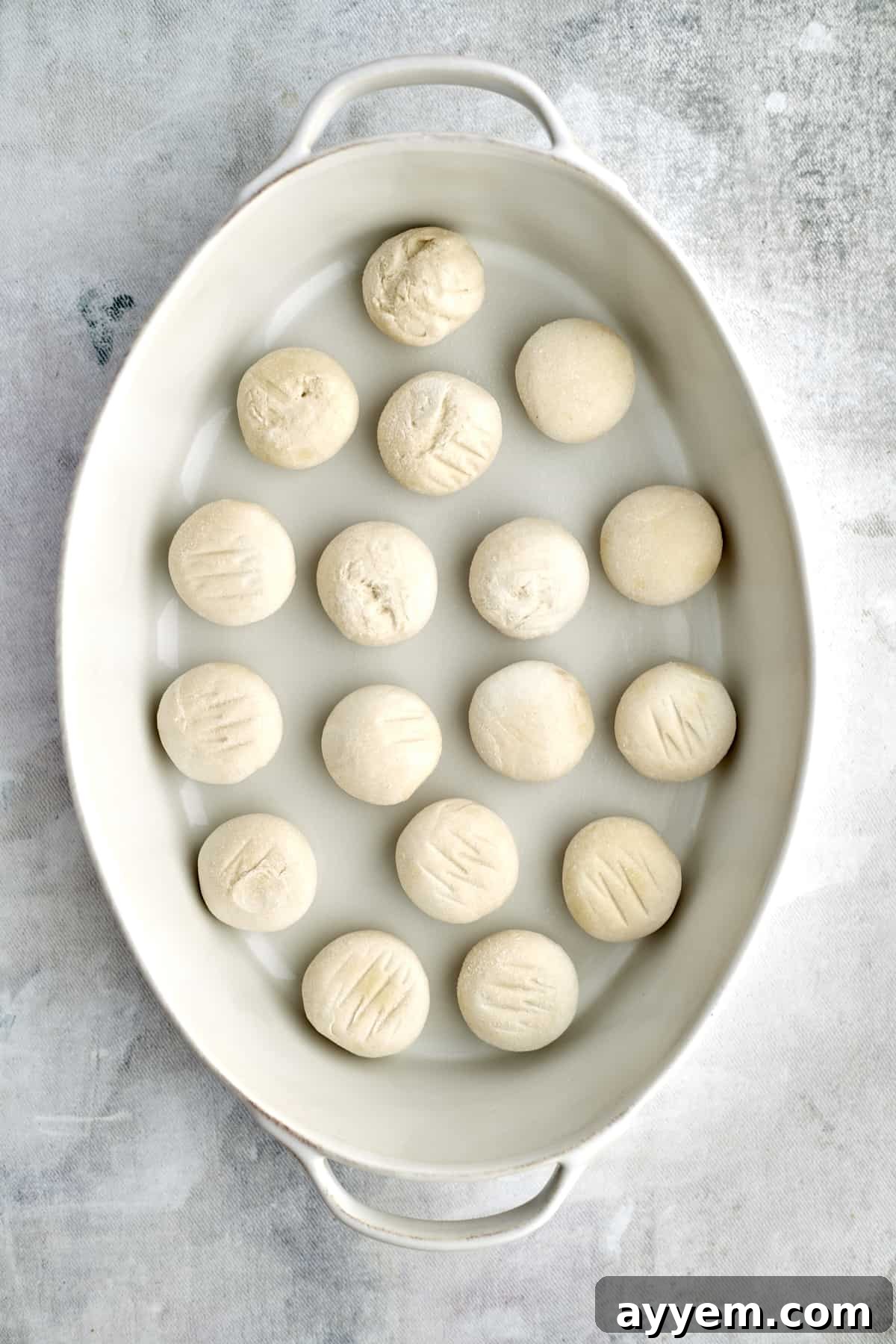 raw bread roll dough in a baking dish 