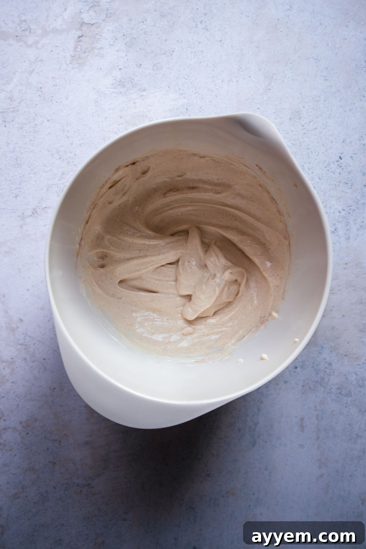 Close-up of the cream cheese, sugar, and cinnamon mixture after being beaten, showing a smooth, creamy texture.