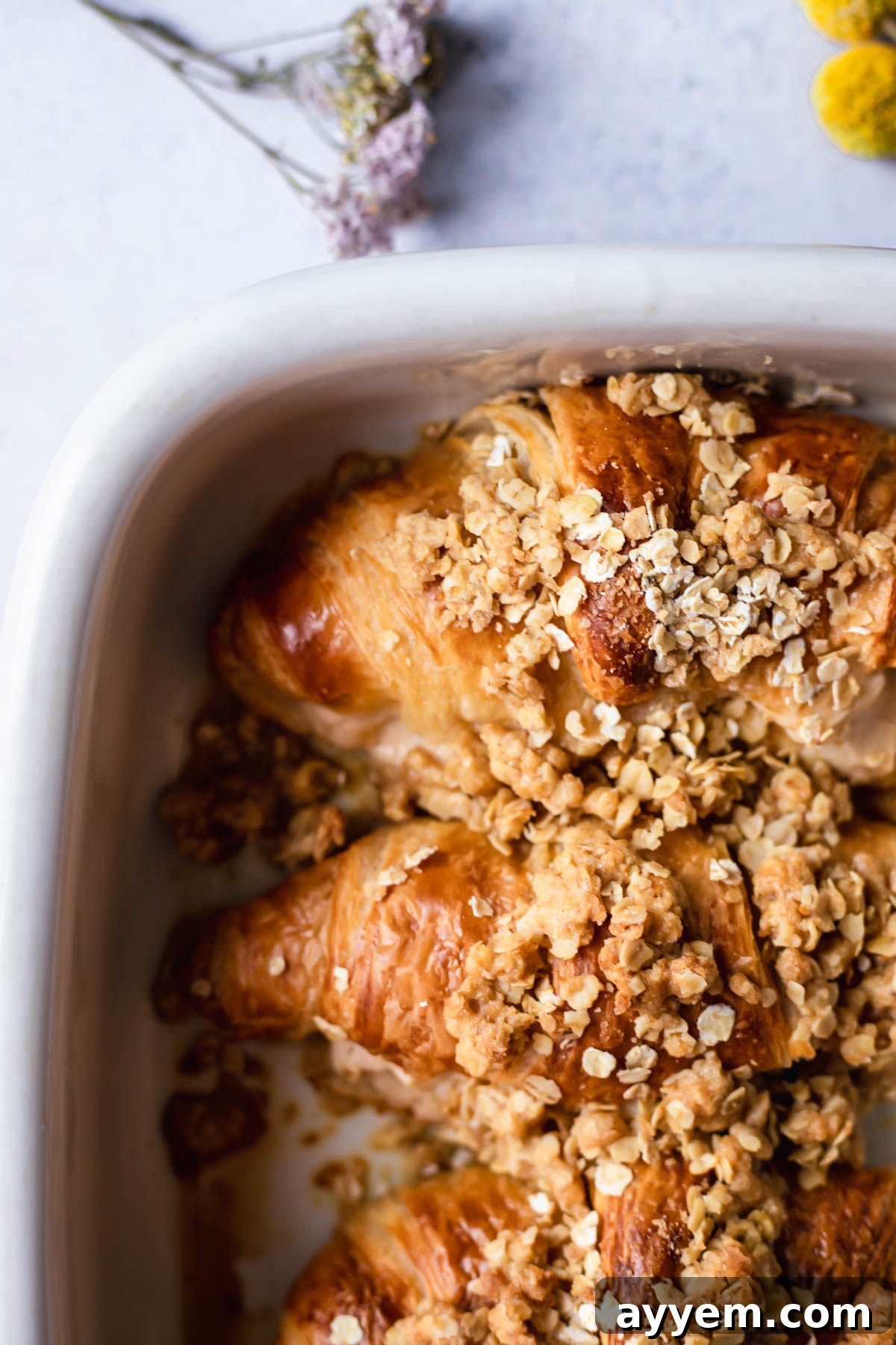 A large baking dish filled with golden-brown cinnamon crisp apple french toast bake croissants, fresh from the oven.