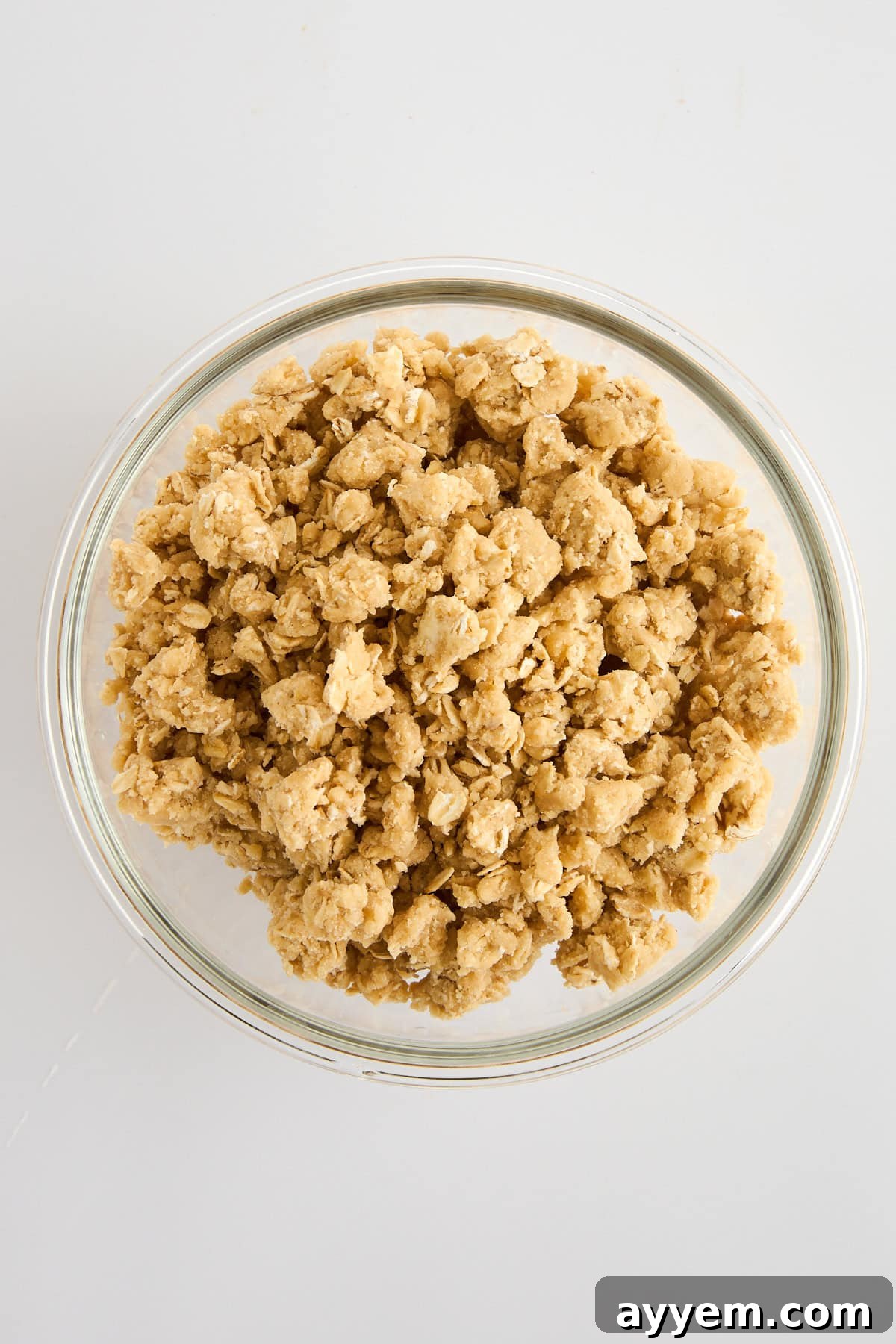 A bowl filled with the prepared oat crumble topping, showing its crumbly texture.