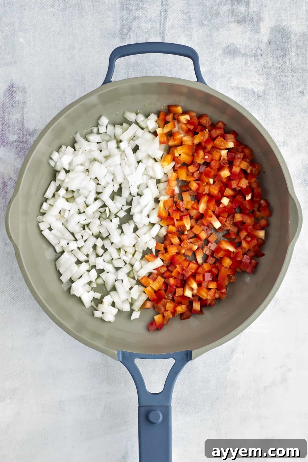 Feta Shakshuka Made Easy 3 Diced onions and bell peppers simmering in a large pot, forming the base of the shakshuka sauce.