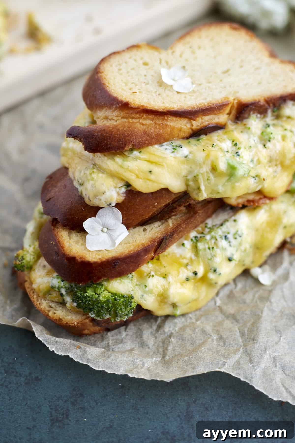 Crispy Oven-Baked Broccoli Cheddar Melts 5 Two perfectly toasted broccoli grilled cheese sandwiches, stacked one on top of the other, showcasing their golden crust and enticing filling.