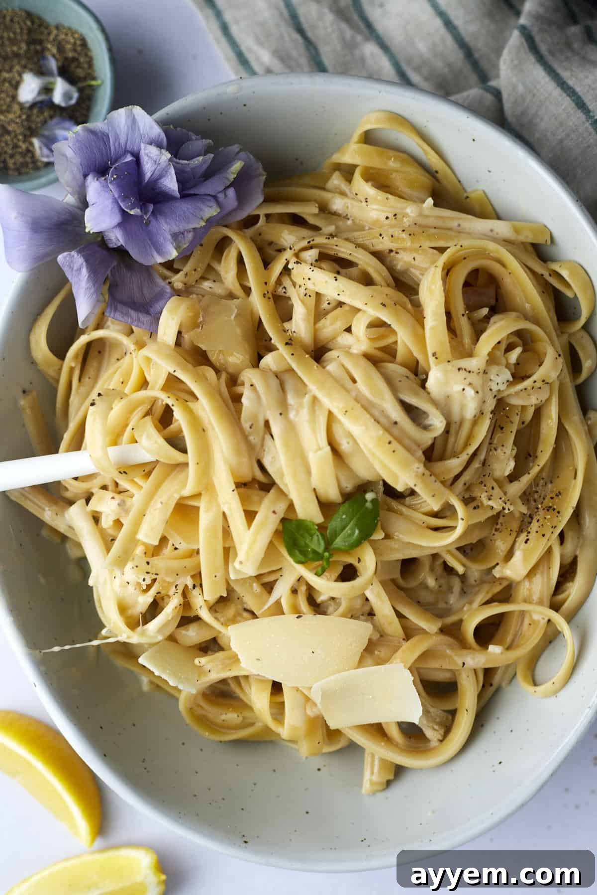 A bowl of one pot fettuccine alfredo with a fork twirled around a bite.