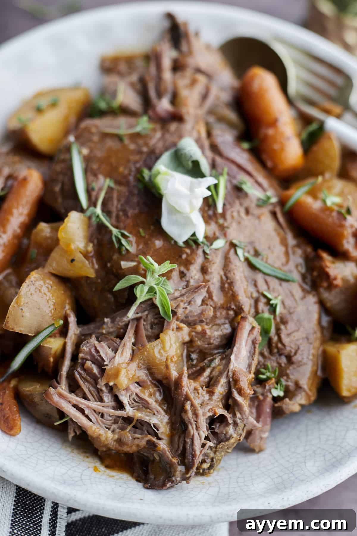 A close-up of a slow cooker beef pot roast, showcasing the tender beef, golden potatoes, and cooked carrots, ready to serve.
