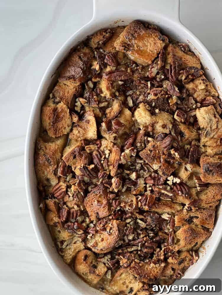 overhead image of panettone bread pudding with pecan pie filling in an oval baking dish.