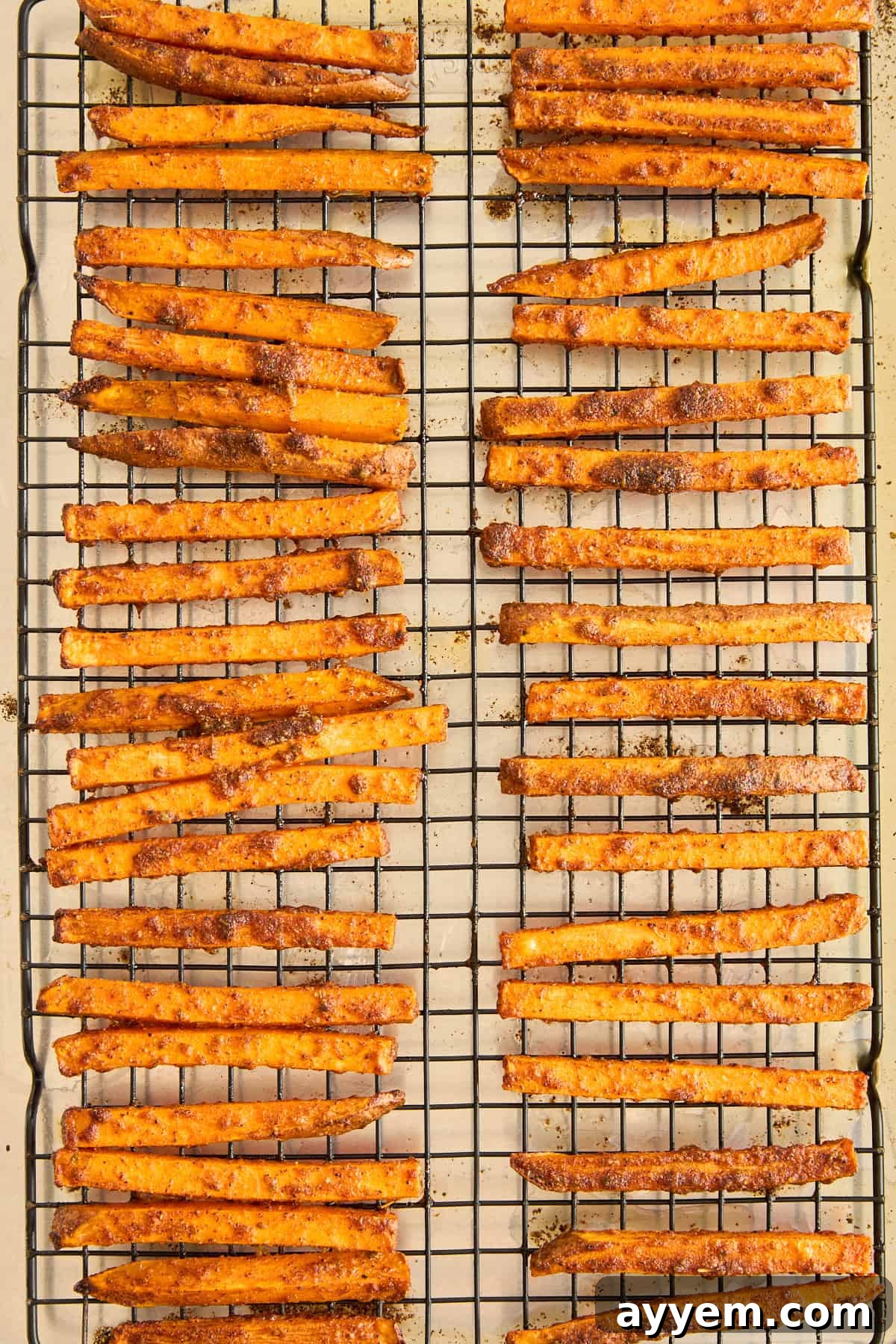 A baking sheet filled with perfectly golden-brown and crispy oven baked sweet potato fries, fresh from the oven and ready to serve.