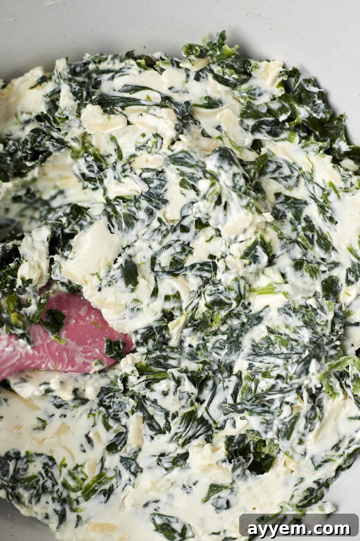 A vibrant bowl of mixed phyllo spinach pie filling, showcasing the creamy blend of cheeses and spinach