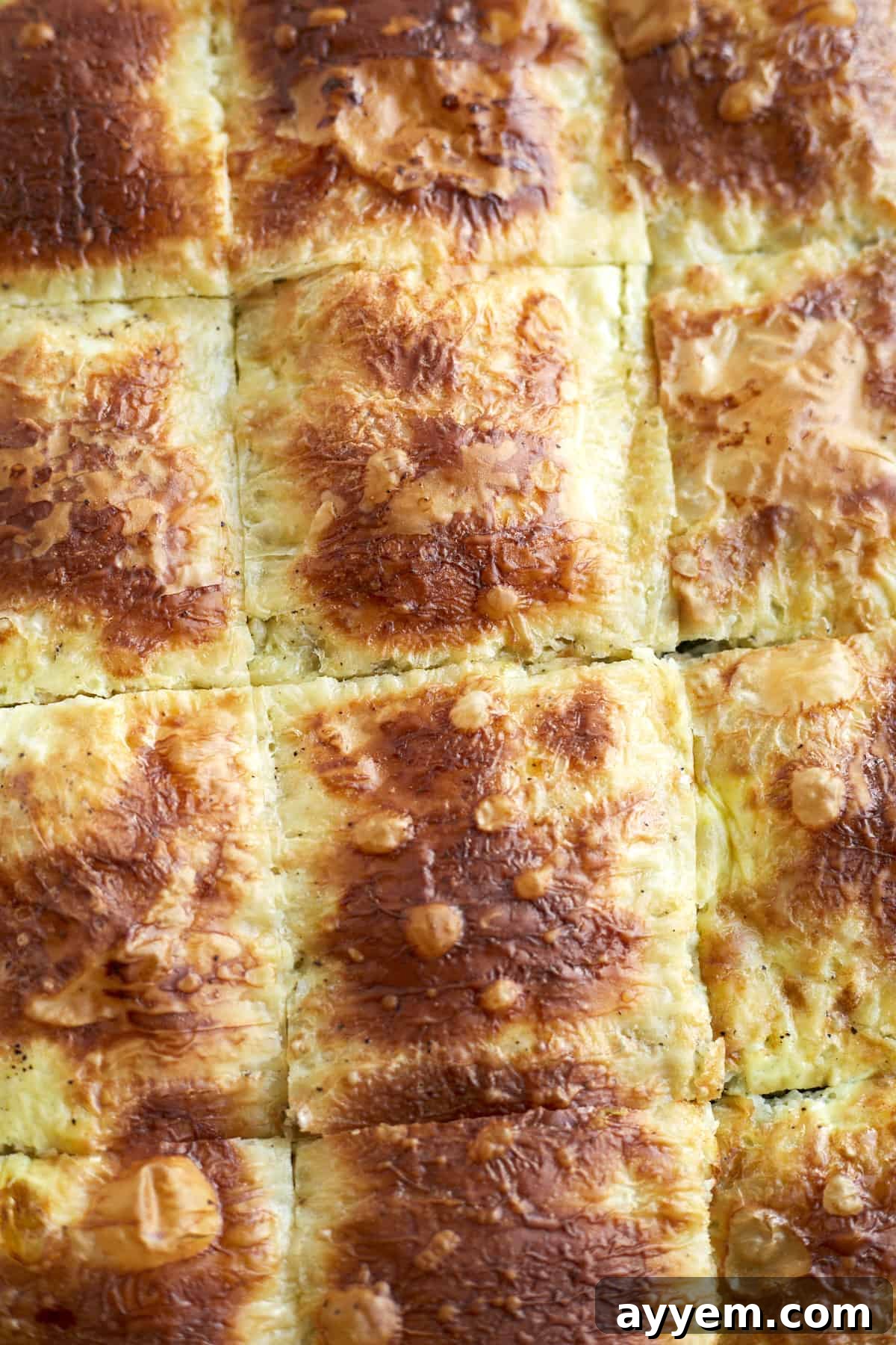 Close-up image of a perfectly baked phyllo spinach pie, highlighting the golden-brown and flaky layers