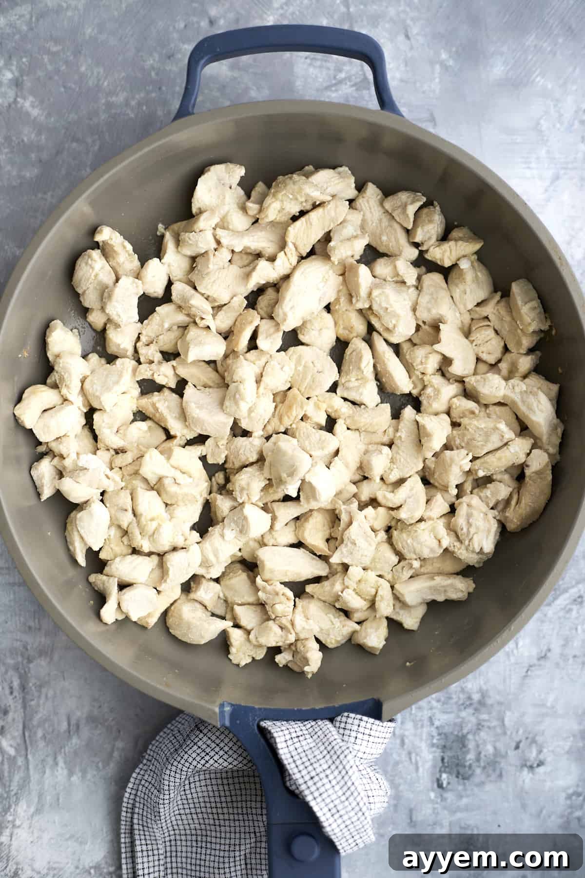 Chicken pieces browning in a skillet, seasoned and ready for sauce.