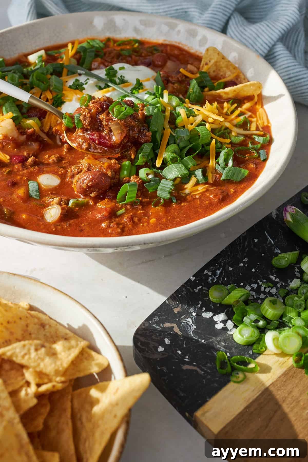 A captivating close-up of a spoon lifting a generous bite of slow cooker chili, showcasing its rich texture and hearty ingredients, ready to be enjoyed.