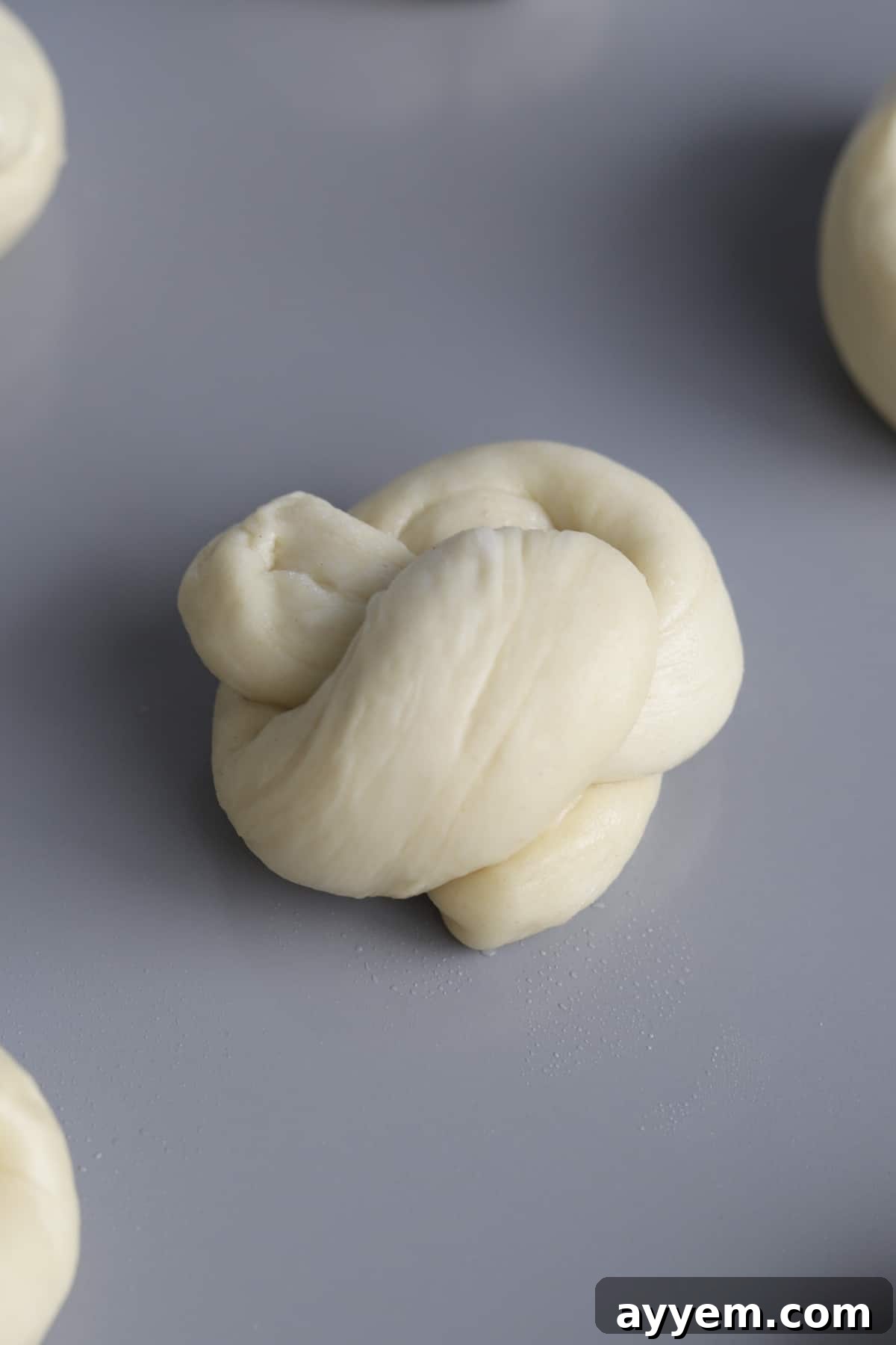 Unbaked garlic knot dough, neatly tied and arranged on a baking sheet, waiting to be transformed.