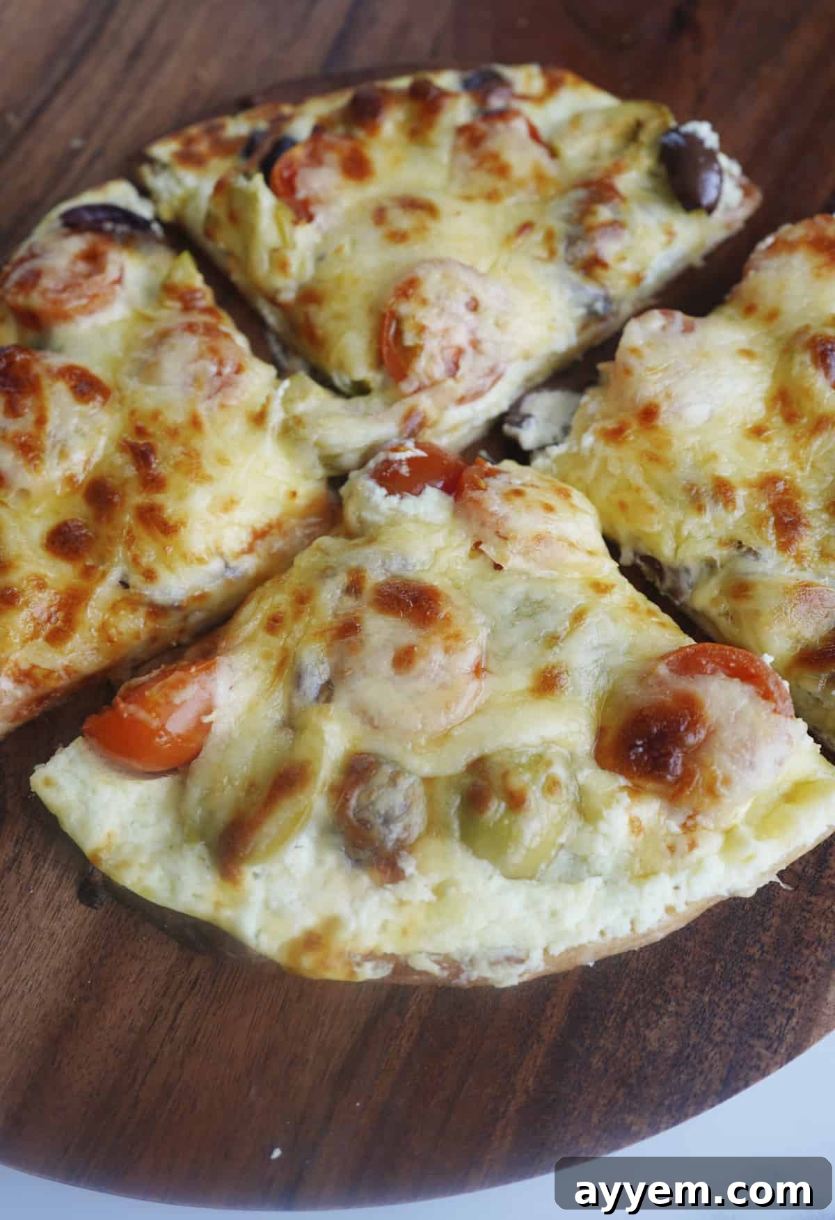 A close-up view of a baked whipped feta pizza, sliced into four generous wedges, ready to be enjoyed.