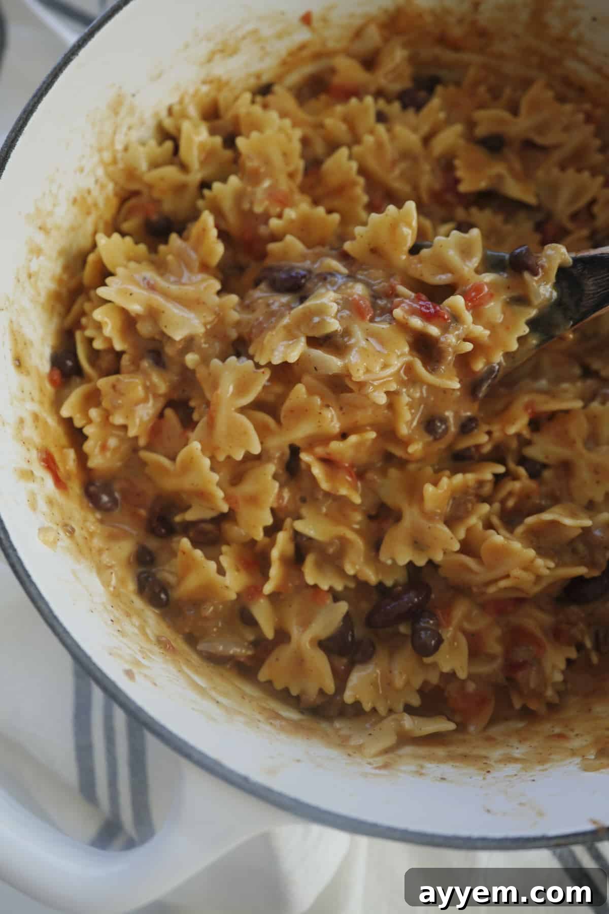 a spoon stirring one pot chili mac and cheese