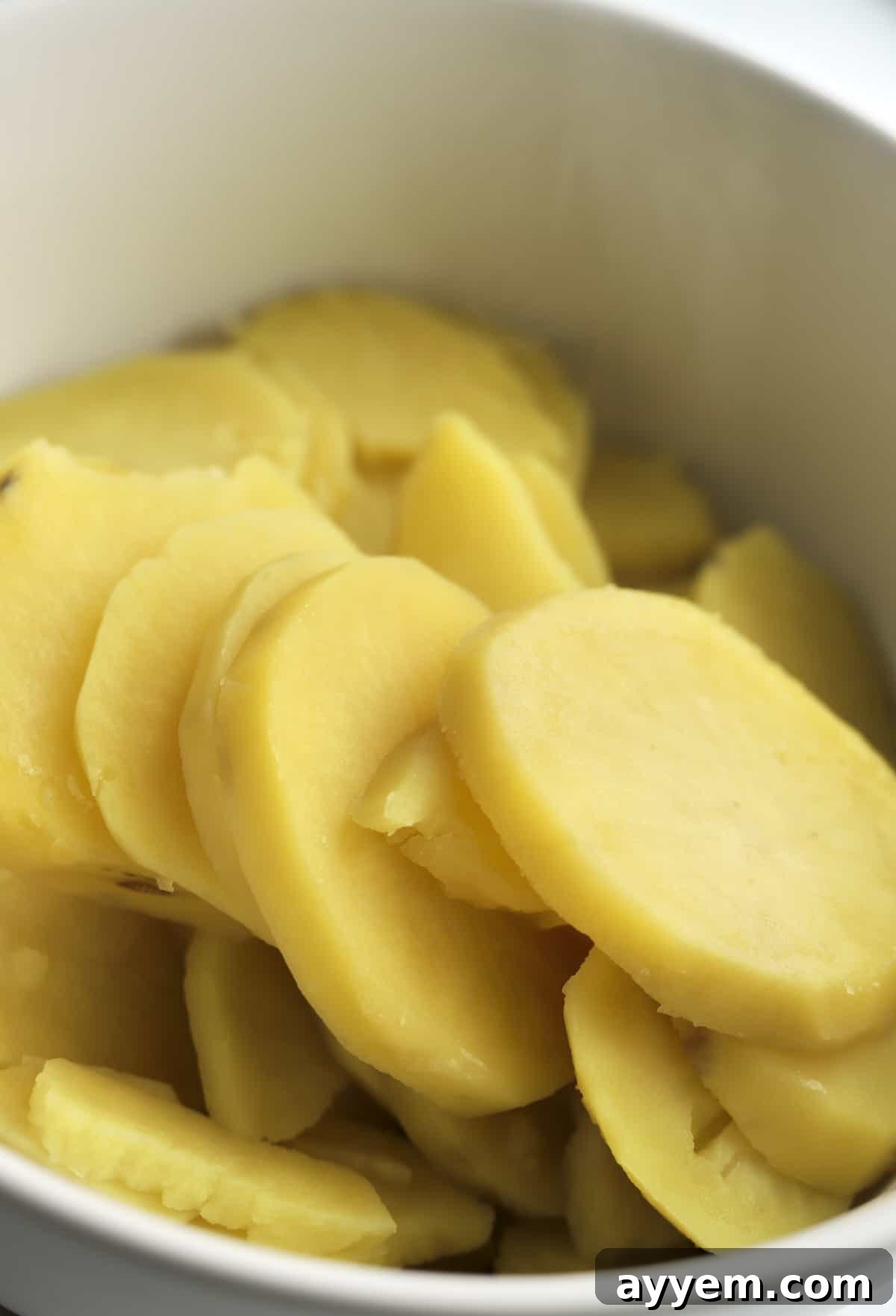 Peeled and sliced Yukon gold potatoes ready for boiling.