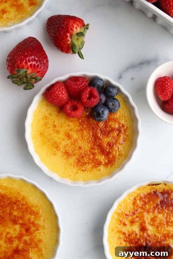 ramekins of creme brulee topped with raspberries and blueberries