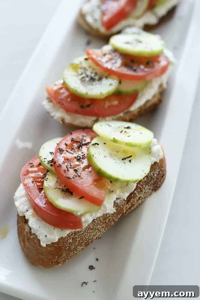 sideview of feta toast with tomatoes and cucumbers
