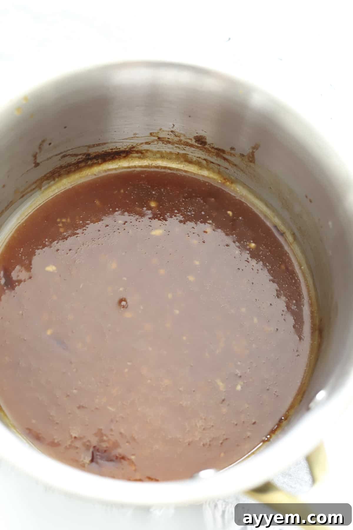 Rich, thick honey garlic glaze simmering in a saucepan.