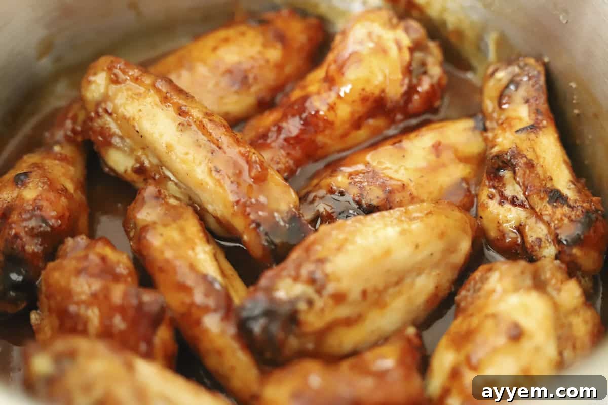 Crispy chicken wings cooking inside an air fryer basket.