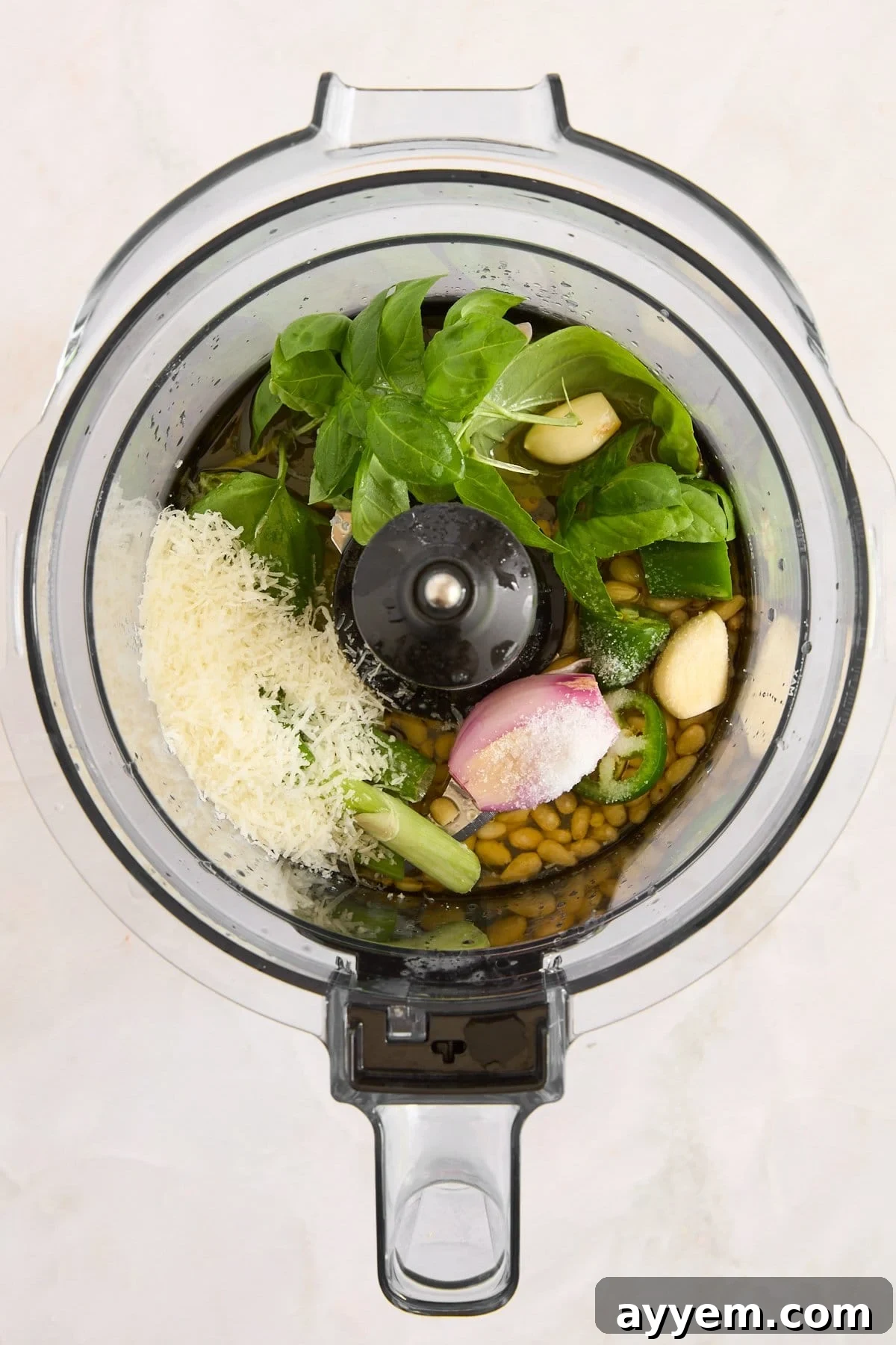 Green goddess dressing ingredients in a food processor, ready to be blended.