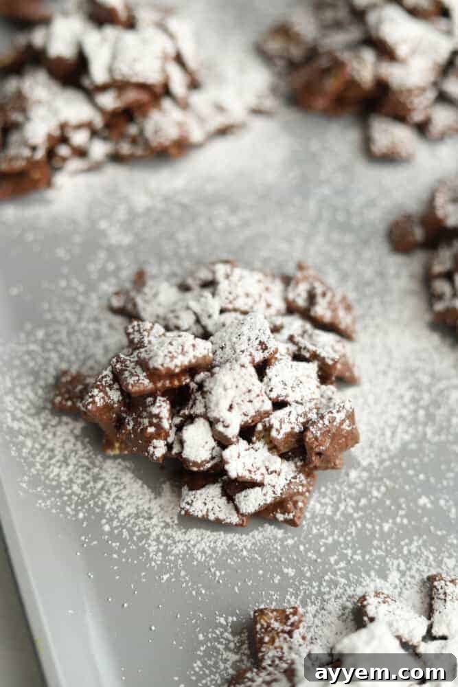 Scooping clusters of puppy chow onto a wax paper-lined baking sheet