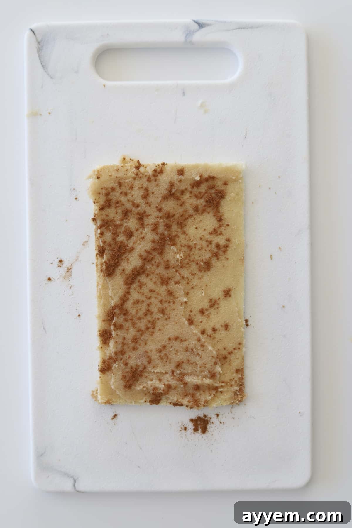a flattened piece of bread topped with a cinnamon sugar mixture