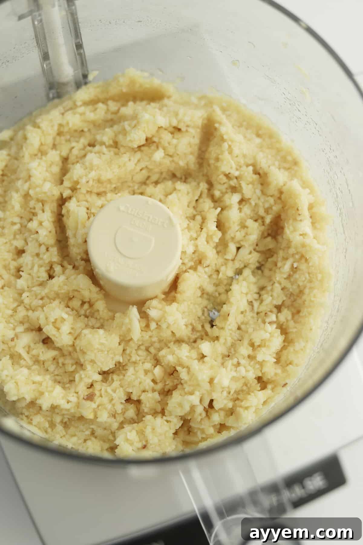 Finely minced garlic in a food processor, illustrating the preparation for freezing methods to ensure convenient portioning and extended shelf life.