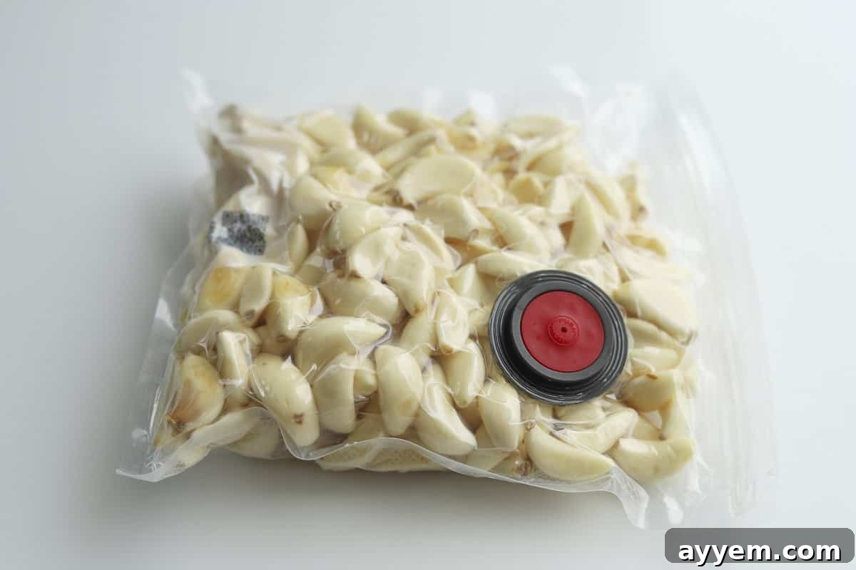Peeled whole garlic cloves in a vacuum-sealed bag, demonstrating an effective long-term storage method to keep garlic fresh and flavorful in the freezer.